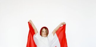 A child joyfully holding a Canadian flag, celebrating patriotism and freedom.