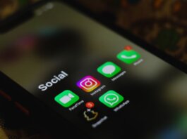 A close-up shot of smartphone displaying social media apps icons on screen.