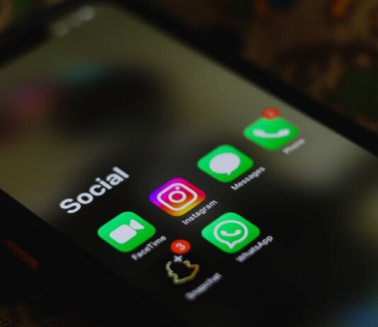 A close-up shot of smartphone displaying social media apps icons on screen.