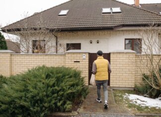Ньюфаундленд и Лабрадор вводит 15-процентную скидку на электроэнергию для жителей A delivery person brings a package to a suburban house on a winter day.