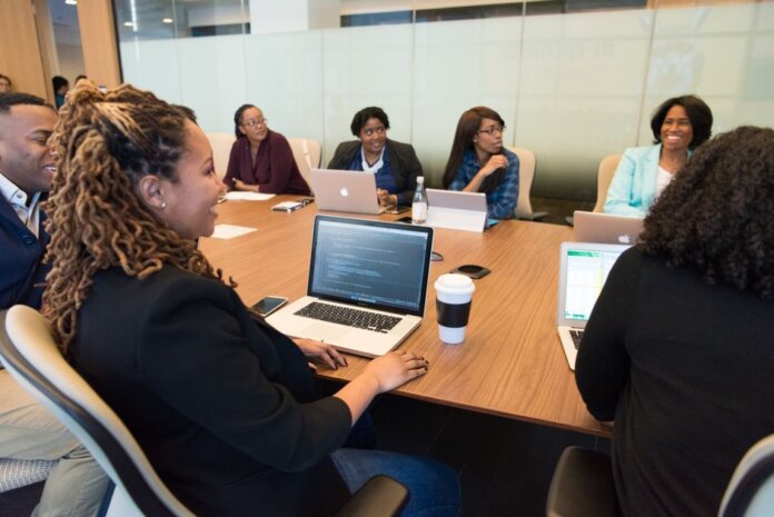 A diverse group of professionals working together in a modern conference room with laptops. A diverse group of professionals working together in a modern conference room with laptops.