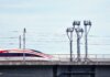 Оттава и Альберта будут сотрудничать в создании высокоскоростной железной дороги A high-speed train moves swiftly on an elevated railway under a clear sky.
