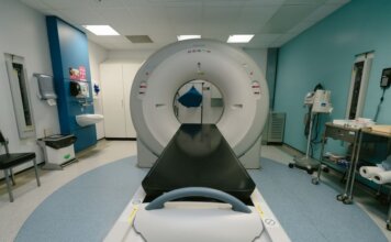 A high-tech MRI machine in a spacious hospital examination room, ready for medical scanning.