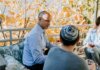 Пьер Пуальевр поздравил еврейские общины Канады с праздником Суккот A Jewish family enjoying a festive outdoor gathering during fall, sharing talks and wine.