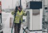 Консерваторы требуют от Оттавы плана по снижению цен на дизельное топливо A man wearing a jacket refuels a truck at a gas station during winter with snow falling.