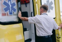 В городке Сук в Британской Колумбии построят центр неотложной и первичной помощи A paramedic in uniform opens the side door of a yellow ambulance during the day.