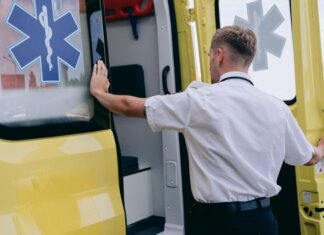 В городке Сук в Британской Колумбии построят центр неотложной и первичной помощи A paramedic in uniform opens the side door of a yellow ambulance during the day.