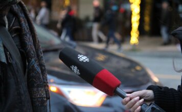 Канада отчиталась о прогрессе в борьбе с угонами автомобилей: что сделано A person being interviewed on a Vancouver street, holding a microphone.