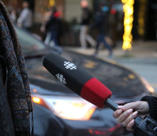 A person being interviewed on a Vancouver street, holding a microphone.