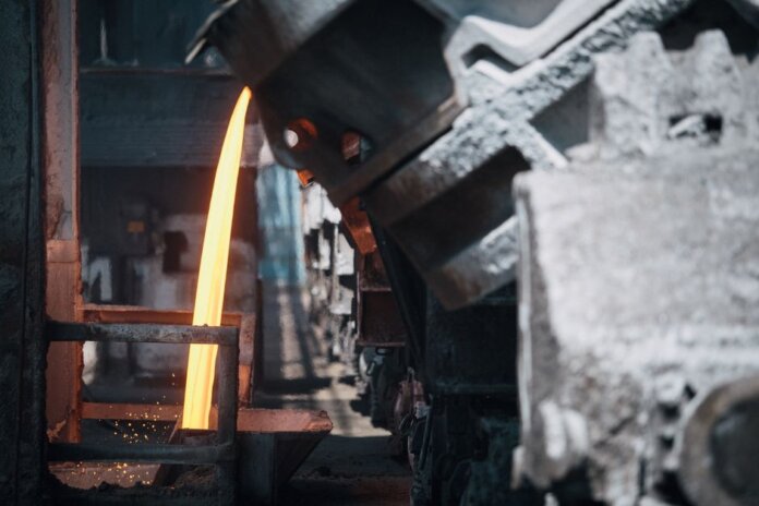 A powerful image of molten metal pouring in a heavy industry steel mill setting. A powerful image of molten metal pouring in a heavy industry steel mill setting.