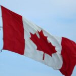 Канада продвигает международное сотрудничество на G20 A vibrant Canadian flag fluttering in the wind, symbolizing national pride.