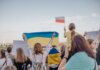 Канада, Украина и Норвегия выступили с заявлением о возвращении украинских детей A vibrant demonstration in Szczecin, Poland featuring crowds waving Polish and Ukrainian flags in unity.