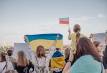 A vibrant demonstration in Szczecin, Poland featuring crowds waving Polish and Ukrainian flags in unity.