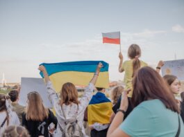 A vibrant demonstration in Szczecin, Poland featuring crowds waving Polish and Ukrainian flags in unity.