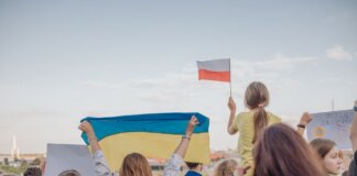 A vibrant demonstration in Szczecin, Poland featuring crowds waving Polish and Ukrainian flags in unity.