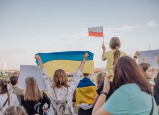 A vibrant demonstration in Szczecin, Poland featuring crowds waving Polish and Ukrainian flags in unity.