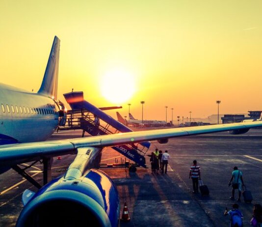 A vibrant image of passengers boarding an airplane at sunrise, highlighting air travel.