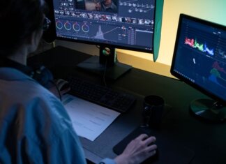 Британская Колумбия открывает площадку для тестирования оборонных технологий A video editor using dual monitors for editing footage in a dimly lit studio.