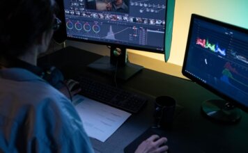 Британская Колумбия открывает площадку для тестирования оборонных технологий A video editor using dual monitors for editing footage in a dimly lit studio.
