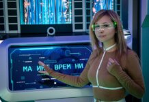 A woman interacts with a futuristic touchscreen display in a technology-themed environment.