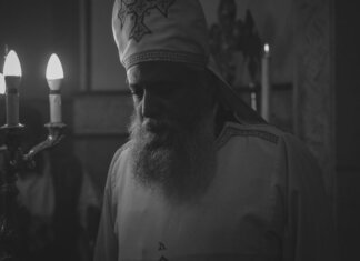 Пьер Пуальевр поздравил коптов Канады с Наврузом — новым годом по коптскому календарю Black and white photo of an Orthodox priest during a candlelit religious ceremony in Cairo, Egypt.