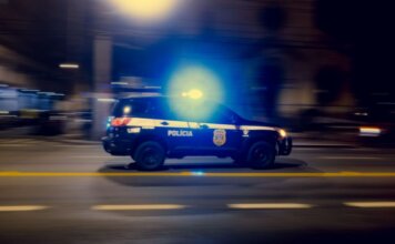 Двое обвиняются в опасном вождении угнанного автомобиля в Реджайне Blurred motion capture of a police car speeding at night with flashing lights on a city street.