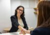 Полиция Дарема приглашает женщин на симпозиум о карьере в 2026 году Businesswomen shaking hands in an office, representing a successful job interview or partnership.