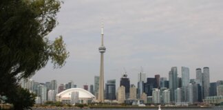 Capture of Toronto's iconic skyline featuring the CN Tower and waterfront on a calm day.