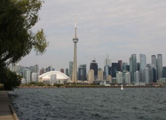 Capture of Toronto's iconic skyline featuring the CN Tower and waterfront on a calm day.