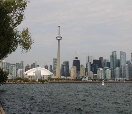 Capture of Toronto's iconic skyline featuring the CN Tower and waterfront on a calm day.