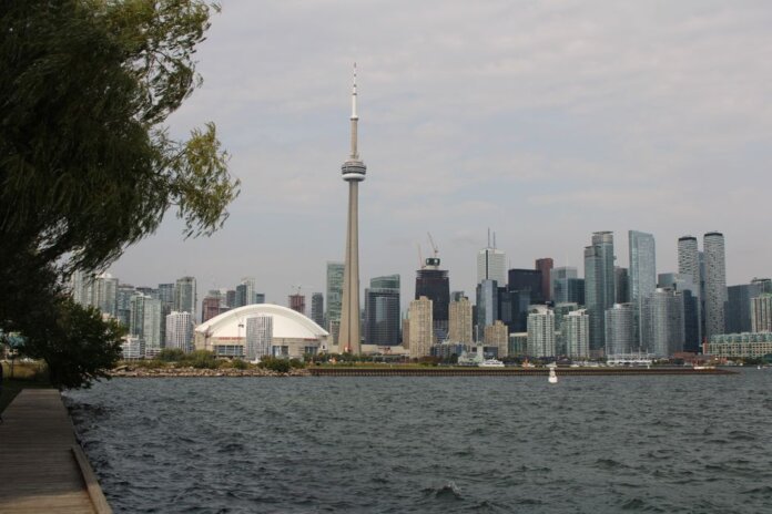 Capture of Toronto's iconic skyline featuring the CN Tower and waterfront on a calm day.