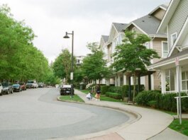 Charming Vancouver street with families enjoying a day outdoors among lined trees and houses. Urban community scene.