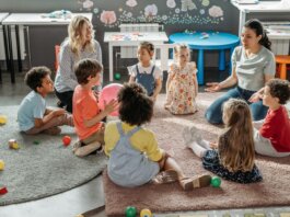 Children in circle time with teachers, engaging in a kindergarten classroom activity.