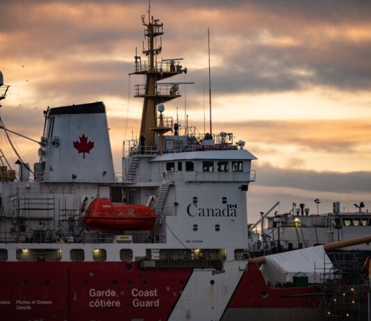 Close-up of a Canadian Coast Guard ship docked at sunset, showcasing maritime details.