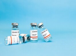 Close-up of COVID-19 vaccine vials against a blue background, symbolizing hope and recovery.