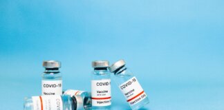 Close-up of COVID-19 vaccine vials against a blue background, symbolizing hope and recovery.