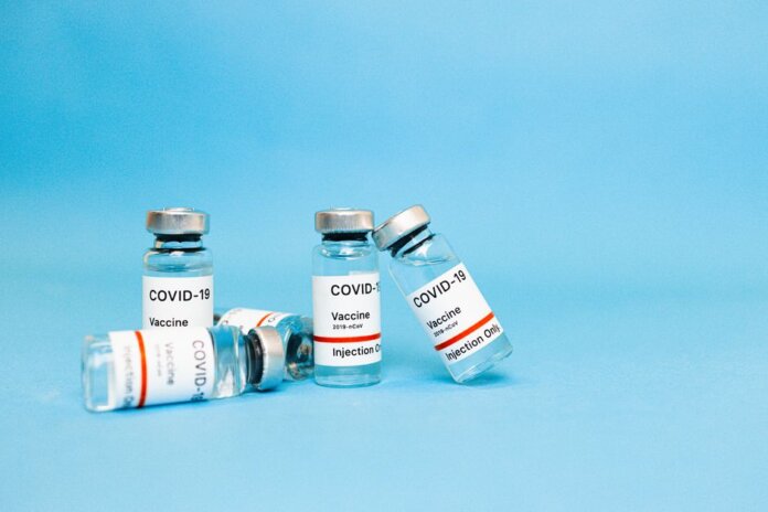 Close-up of COVID-19 vaccine vials against a blue background, symbolizing hope and recovery. Close-up of COVID-19 vaccine vials against a blue background, symbolizing hope and recovery.