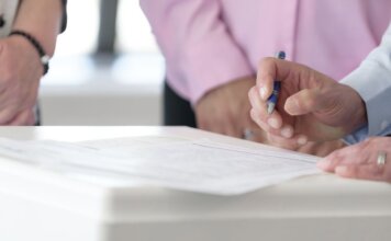Канада и Сингапур объявили о рамках экономического партнёрства Close-up of hands signing documents in an office setting, emphasizing collaboration and decision-making.