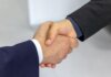 Глава МИД Канады Анита Ананд встретилась с министром по международному сотрудничеству Катара Close-up of two businessmen shaking hands, symbolizing agreement and partnership.