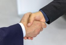 Close-up of two businessmen shaking hands, symbolizing agreement and partnership.