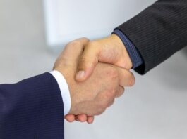 Close-up of two businessmen shaking hands, symbolizing agreement and partnership.