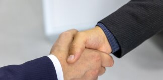 Close-up of two businessmen shaking hands, symbolizing agreement and partnership.