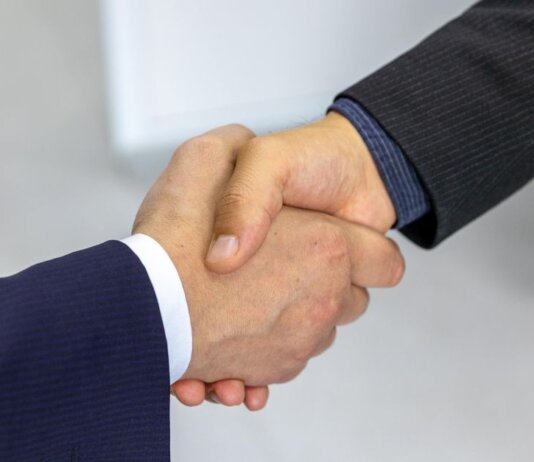 Close-up of two businessmen shaking hands, symbolizing agreement and partnership.