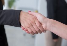 Close-up of two businesswomen shaking hands symbolizing agreement.