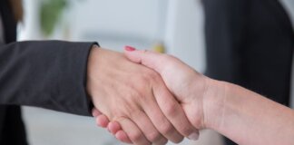 Close-up of two businesswomen shaking hands symbolizing agreement.