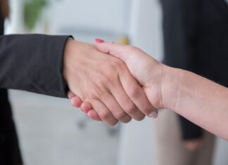 Close-up of two businesswomen shaking hands symbolizing agreement.