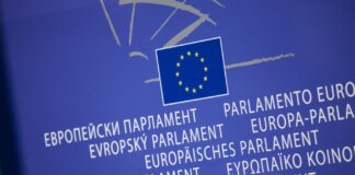 Close-up view of the European Union flag with multilingual text showing European Parliament.
