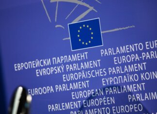 Close-up view of the European Union flag with multilingual text showing European Parliament.