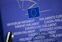 Close-up view of the European Union flag with multilingual text showing European Parliament.