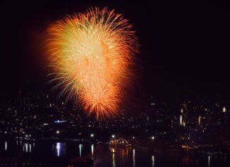 Colorful fireworks illuminate the cityscape at night, creating a festive and vibrant atmosphere.